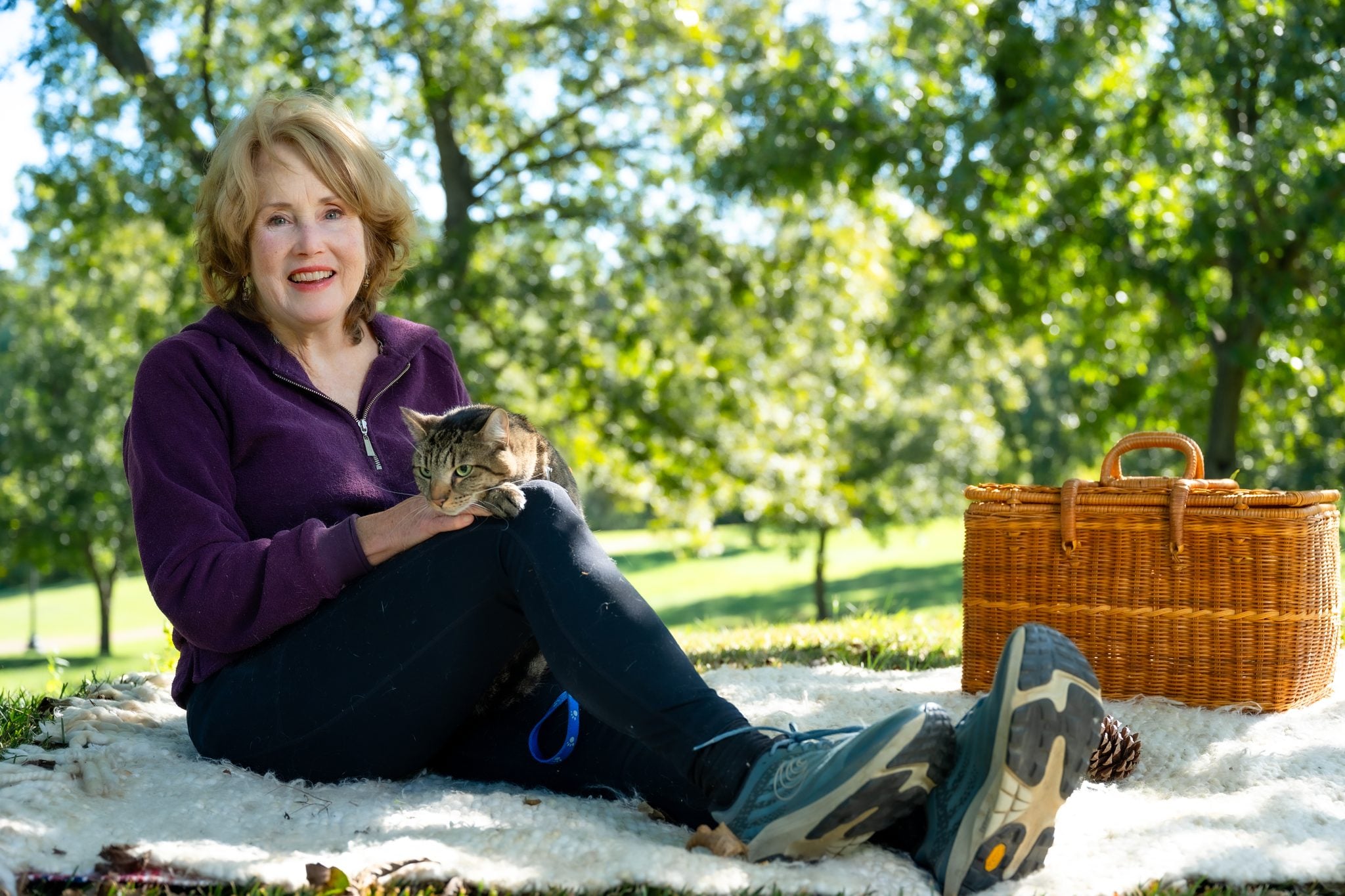 Susan on a blanket in the Pecan Grove with Wilson on her knee, picnic basket beside her